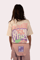 T-shirt natif good vibes porté une femme avec une fleur et des couleurs beige, rose et violet en coton avec col rond
