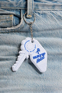 Porte-clés key of happiness doré en forme de clé décorative sur fond blanc