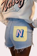 Short pour femme Natif en denim, couleur bleu avec poche jaune et logo rose, pour un style good vibes