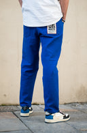 Pantalon Natif Porquerolles couleur bleu avec des symboles de l'île en blanc, bouton pressions et broderies pour un style good vibes