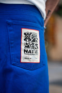 Pantalon Natif Porquerolles couleur bleu avec des symboles de l'île en blanc, bouton pressions et broderies pour un style good vibes