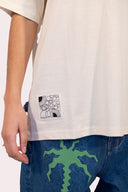 Etiquette du t-shirt unisexe Natif Elements, coton bio et col rond, couleur crème avec des fleurs, soleil et des élèments Natif pour un style connecté à la nature
