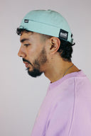 Bonnet style milky en coton bio bleu avec système de réglage pour adulte et une fleur brodée de la marque de vêtements Natif