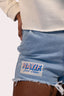 Short pour femme Natif en denim, couleur bleu avec poche jaune et logo rose, pour un style good vibes