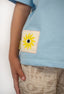 T-shirt Natif del sol, couleur bleu avec un grand soleil, dans un style surf et good vibes pour les enfants.